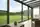 Moderne aluminium veranda met panoramisch tuinzicht in Ronse
